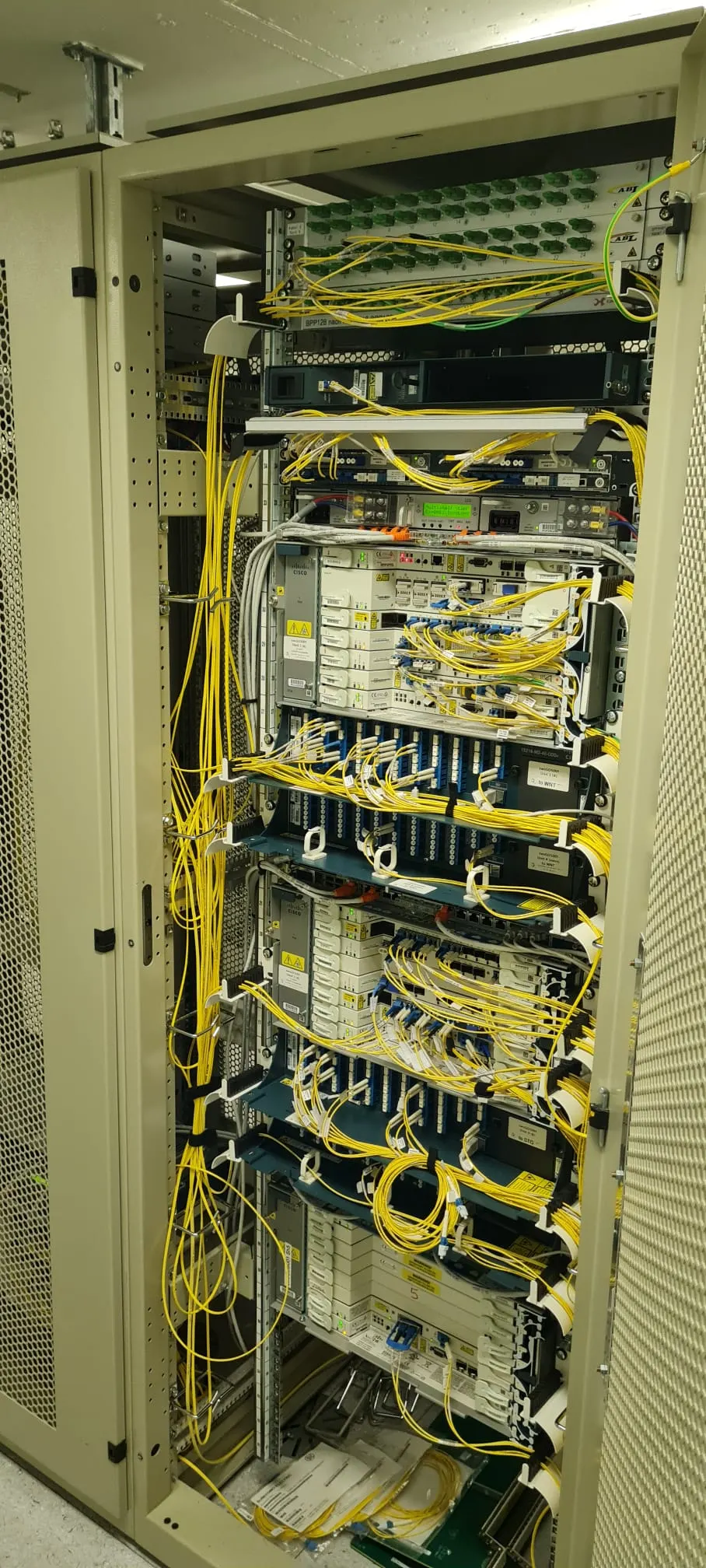Voll bestückter Rack in einer Zentrale mit sauber geführten gelben Patchkabeln